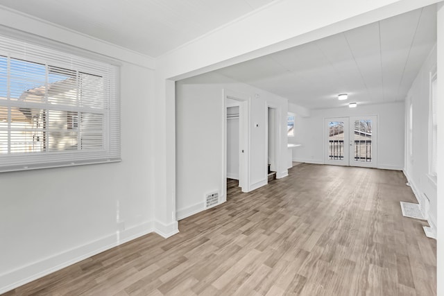 unfurnished living room with light wood-type flooring and french doors