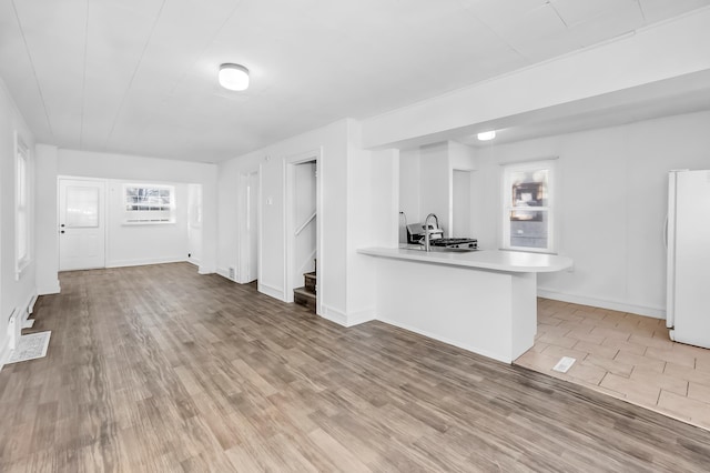 unfurnished living room featuring hardwood / wood-style flooring and sink