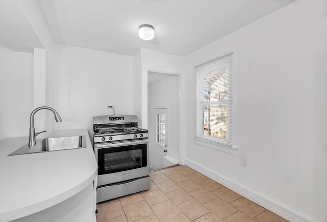 kitchen featuring light tile patterned floors, sink, and gas range