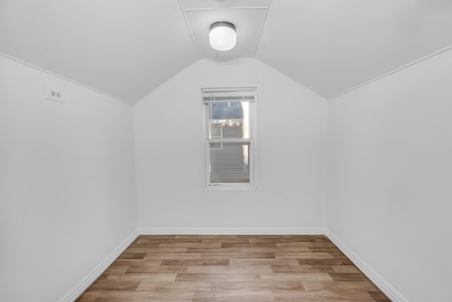 additional living space with light hardwood / wood-style flooring and lofted ceiling