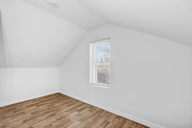 bonus room featuring lofted ceiling and light wood-type flooring