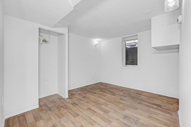 interior space featuring a textured ceiling and light hardwood / wood-style floors