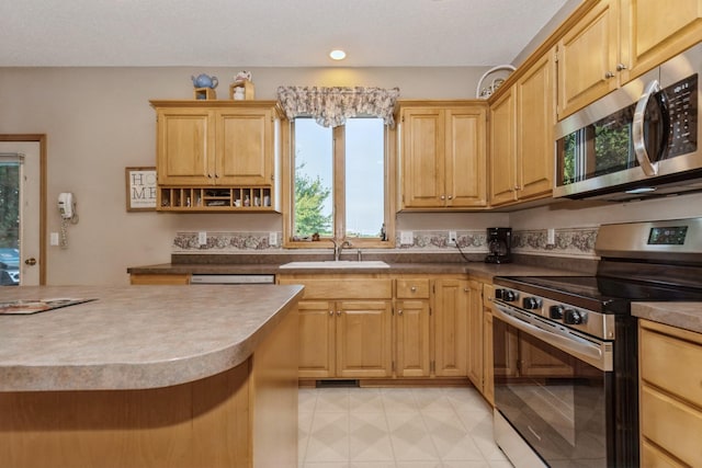 kitchen with light brown cabinetry, stainless steel appliances, and sink