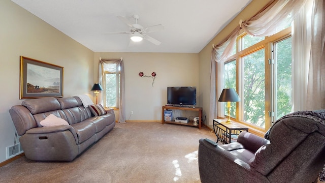 living room with ceiling fan, light carpet, and a wealth of natural light