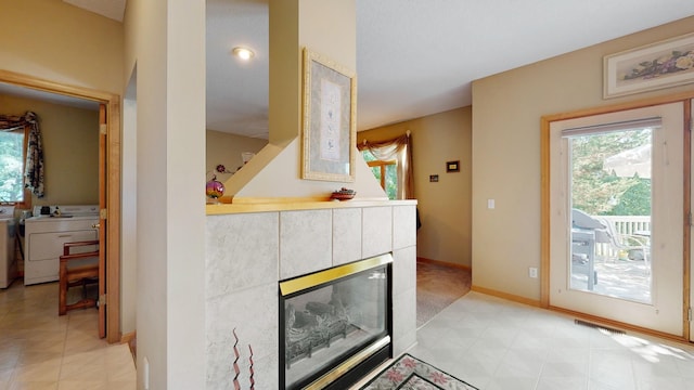 room details featuring a tiled fireplace and washer / dryer