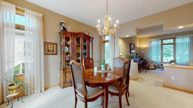 dining area featuring light colored carpet and a chandelier