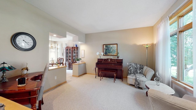 sitting room with a chandelier, light carpet, and a wealth of natural light