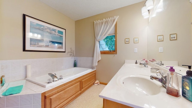 bathroom with vanity, a bathtub, and a textured ceiling