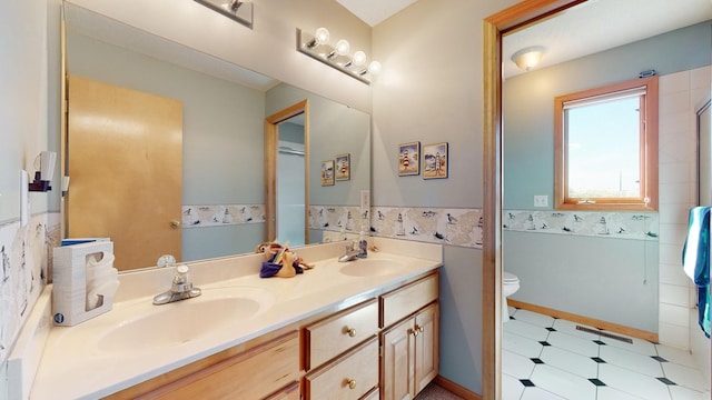 bathroom featuring vanity, a shower with shower door, and toilet