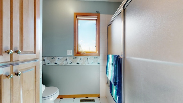 bathroom with an enclosed shower, tile patterned floors, and toilet