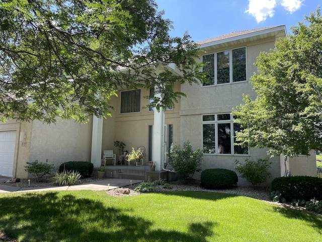 view of front of house with stucco siding and a front yard