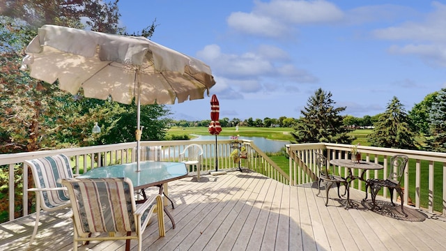 wooden deck featuring outdoor dining area and a water view