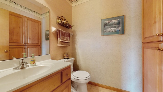 half bath with tile patterned floors, baseboards, toilet, and vanity