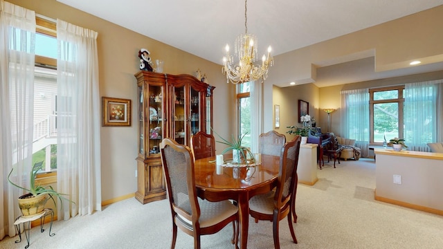 dining area featuring baseboards, light colored carpet, and a chandelier