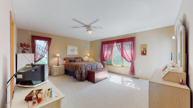 bedroom with visible vents, multiple windows, a textured ceiling, and carpet