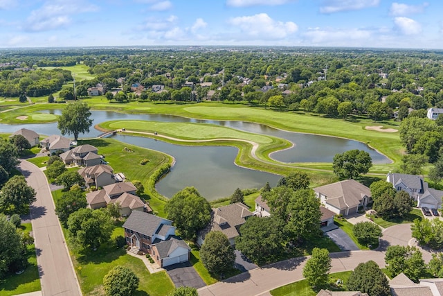 drone / aerial view featuring golf course view, a water view, and a residential view