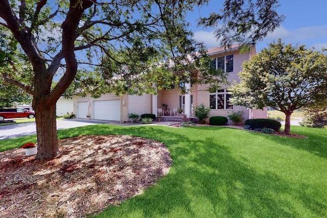 view of front of property with stucco siding, a garage, concrete driveway, and a front yard