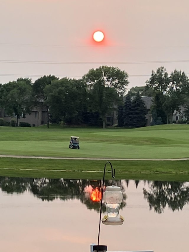 view of home's community featuring a yard, a water view, and golf course view