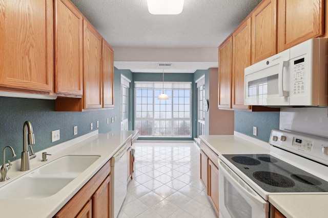 kitchen featuring white appliances, sink, light tile patterned floors, decorative light fixtures, and a notable chandelier