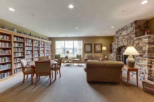 interior space featuring a stone fireplace, carpet floors, and a textured ceiling