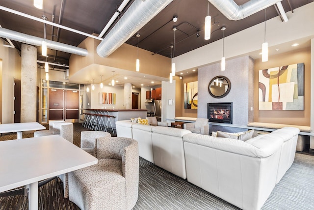 living room with a large fireplace and a towering ceiling