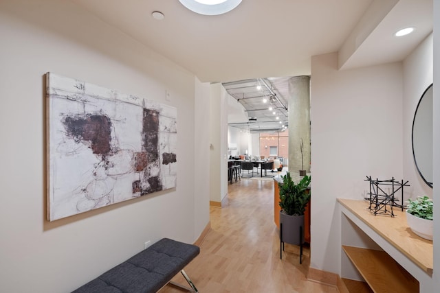 corridor featuring track lighting and light hardwood / wood-style flooring