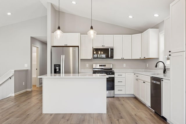 kitchen with pendant lighting, a center island, sink, appliances with stainless steel finishes, and white cabinetry