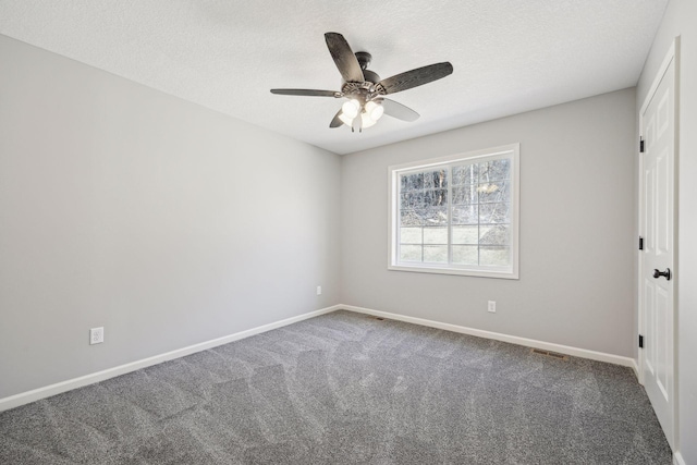 carpeted spare room featuring ceiling fan and a textured ceiling