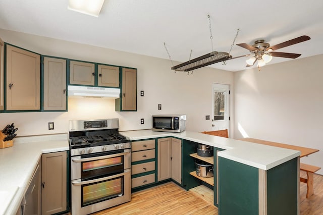 kitchen with ceiling fan, under cabinet range hood, light wood-style flooring, appliances with stainless steel finishes, and a peninsula