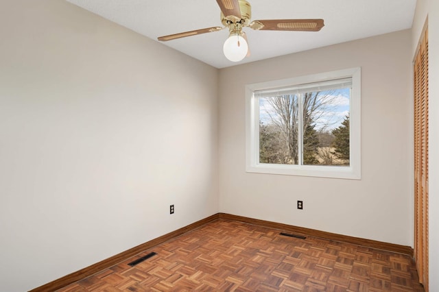 empty room with a ceiling fan, baseboards, and visible vents