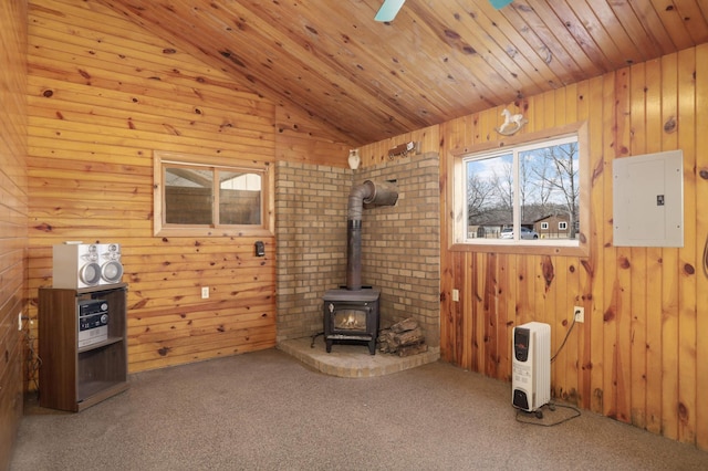 unfurnished living room featuring electric panel, wooden ceiling, carpet flooring, a wood stove, and vaulted ceiling