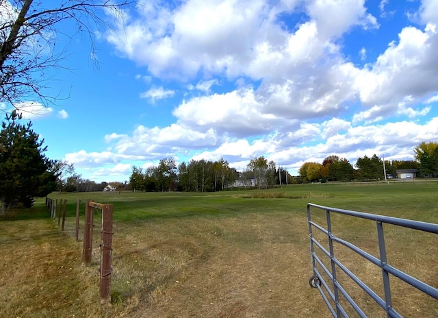 view of yard with a rural view and fence