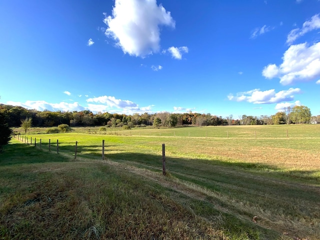 view of yard featuring a rural view and fence