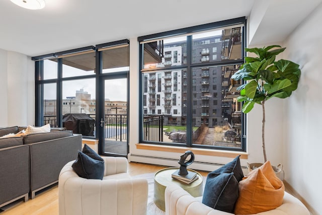 living room with light hardwood / wood-style flooring, floor to ceiling windows, and a baseboard heating unit