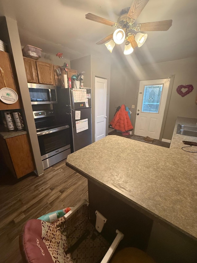 kitchen featuring stainless steel appliances, dark wood-type flooring, and ceiling fan