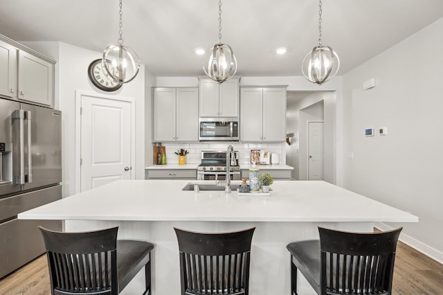 kitchen with an island with sink and appliances with stainless steel finishes