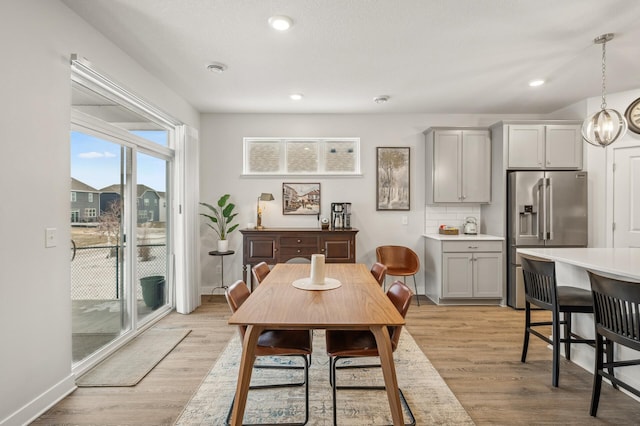 dining area featuring light hardwood / wood-style floors and an inviting chandelier