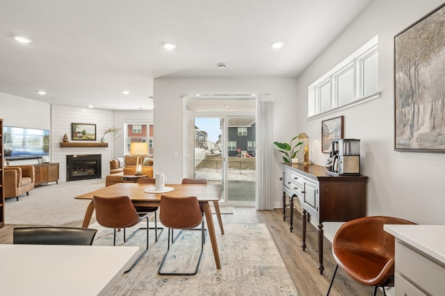 dining area featuring light hardwood / wood-style flooring and a fireplace