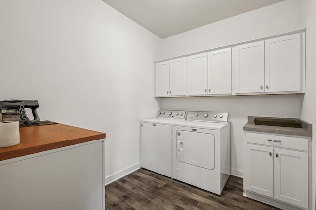 washroom featuring washing machine and dryer, dark wood-type flooring, and cabinets