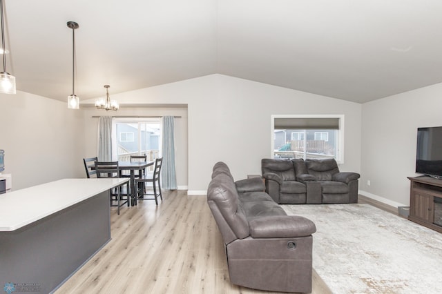 living room featuring light hardwood / wood-style flooring, vaulted ceiling, and an inviting chandelier