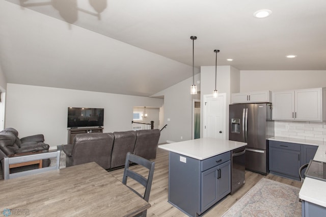 kitchen with a center island, white cabinets, hanging light fixtures, appliances with stainless steel finishes, and tasteful backsplash