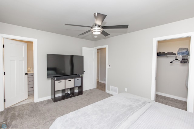 carpeted bedroom with a walk in closet, ceiling fan, and a closet