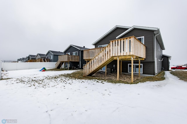 snow covered property featuring a wooden deck and cooling unit