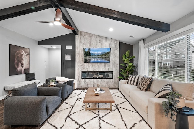 living room with ceiling fan, a fireplace, lofted ceiling with beams, and hardwood / wood-style flooring