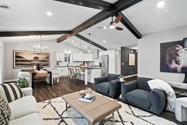 living room featuring lofted ceiling with beams, dark hardwood / wood-style floors, sink, and ceiling fan with notable chandelier