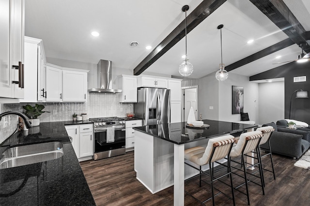 kitchen featuring backsplash, white cabinets, wall chimney range hood, sink, and appliances with stainless steel finishes