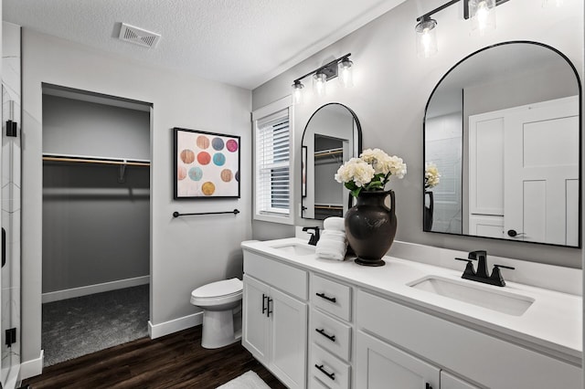 bathroom with toilet, vanity, a textured ceiling, and hardwood / wood-style flooring