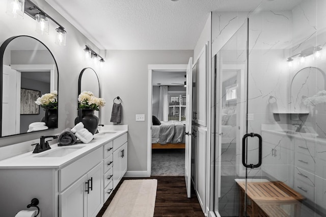 bathroom with hardwood / wood-style flooring, vanity, a textured ceiling, and walk in shower