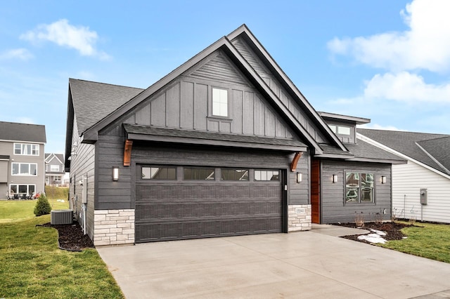 view of front facade featuring a front yard, central AC, and a garage