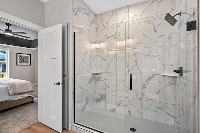 bathroom with ceiling fan, hardwood / wood-style floors, and a shower with door